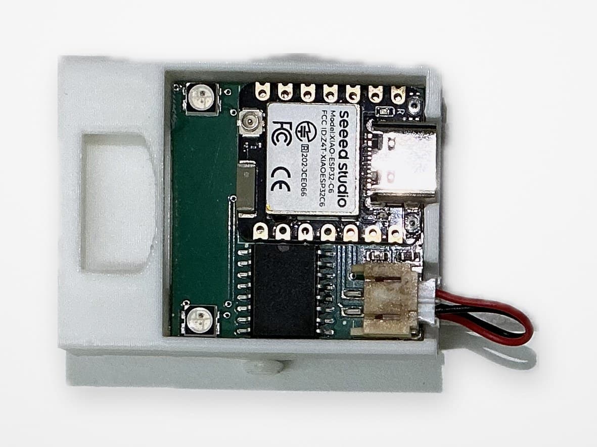 Prototype 2 with its enclosure open: the ESP32-C6 module, status LEDs, and battery connector